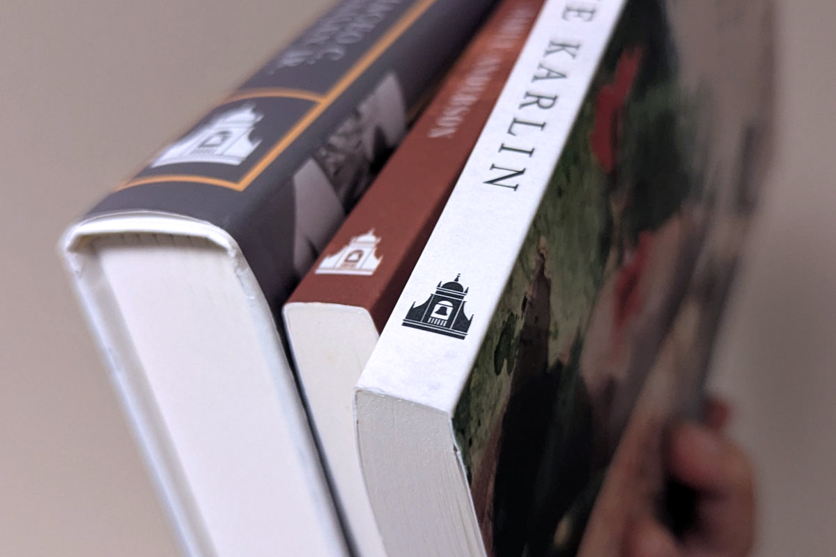 A focused view of the Texas Tech University Press logo on three different book spines ranging from small to large.